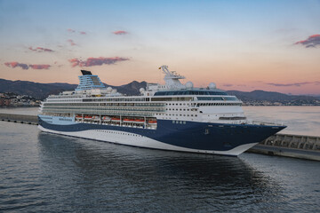 Modern cruiseship cruise ship liner Explorer 2 docked at pier in Malaga, Spain during Mediterranean summer cruising during beautiful sunset with tender boats and ocean views