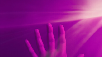 Obraz premium Hand reaching for bright light beams on purple background