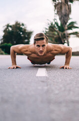 Obraz premium Determined Caucasian male training during morning pushing up enjoying activity and healthy lifestyle, shirtless sportsman practice plank exercises toning physical strength during cardio workout
