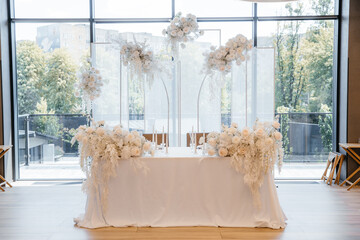 Decorating a hall for an expensive luxury wedding in a restaurant with lights, flowers, and seating details for guests