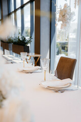 Decorating a hall for an expensive luxury wedding in a restaurant with lights, flowers, and seating details for guests