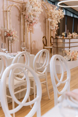 Decorating a hall for an expensive luxury wedding in a restaurant with lights, flowers, and seating details for guests