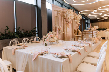 Decorating a hall for an expensive luxury wedding in a restaurant with lights, flowers, and seating details for guests