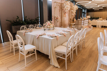 Decorating a hall for an expensive luxury wedding in a restaurant with lights, flowers, and seating details for guests