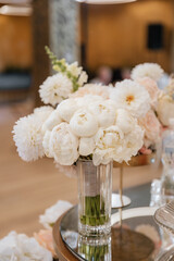 Decorating a hall for an expensive luxury wedding in a restaurant with lights, flowers, and seating details for guests