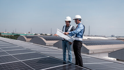 Engineers walking on roof inspect and check solar cell panel by hold equipment box and radio...