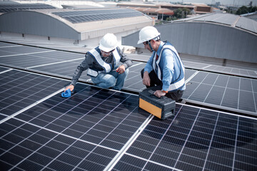 Engineers walking on roof inspect and check solar cell panel by hold equipment box and radio...