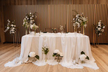 Decorating a hall for an expensive luxury wedding in a restaurant with lights, flowers, and seating details for guests