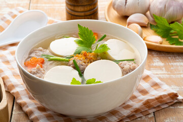 Clear soup with soy bean curd ,Minced Pork and Vegetables in white bowl