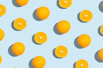 Pattern of an orange slices on pastel blue background. Creative fruit pattern