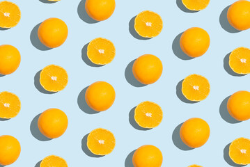 Pattern of an orange slices on pastel blue background. Creative fruit pattern