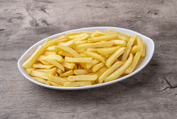 French fries in a plate over wooden table