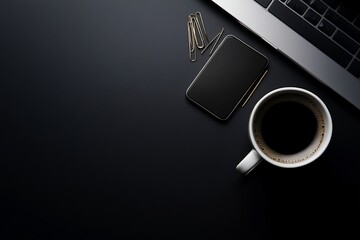 Black desk with laptop, phone, coffee, clips, work from home office setup