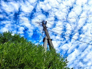 Old pole with wires against the sky. Electric transmission line. Eco-friendly energy