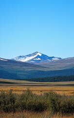 Fototapeta premium Majestic Snow-Capped Mountain Peak Dominates Serene Valley Landscape