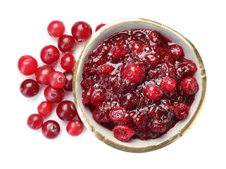Tasty cranberry sauce in bowl and berries isolated on white, top view
