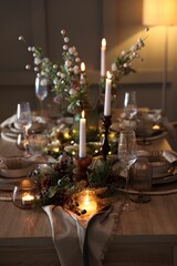 Christmas celebration. Festive table setting with dishware, glasses and decor in room