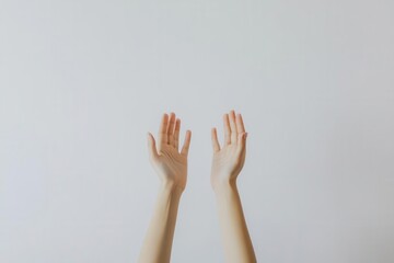 Hands raised in a gesture of openness against a plain background.