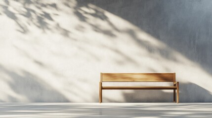 Obraz premium Simple wooden bench in a sunlit modern space with concrete wall and shadows of leaves.