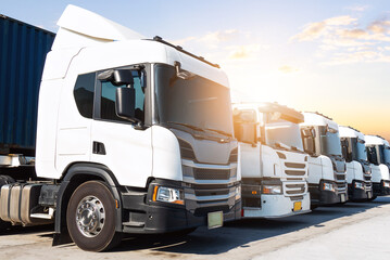 Row of Semi Trucks on The Parking Lot at Warehouse Port. Cargo Container Shipping. Economy Business Transport on Road. Import- Export. Trucking. Lorry Diesel Truck. Freight Logistics Transportation.