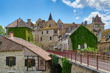 Titel: View at the medieval village of Carennac in Lot Occitanie Southern France with bridge under a blue sky with clouds in summer
