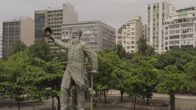 Flying around Admiral Barroso Monument at Paris Square with urban buildings in background, aerial view of Gloria district in Rio de Janeiro, Brazil