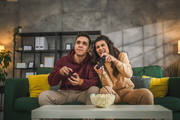 couple man and woman husband wife play console video games at home © Miljan Živković