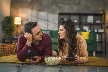 couple man and woman husband wife play console video games at home