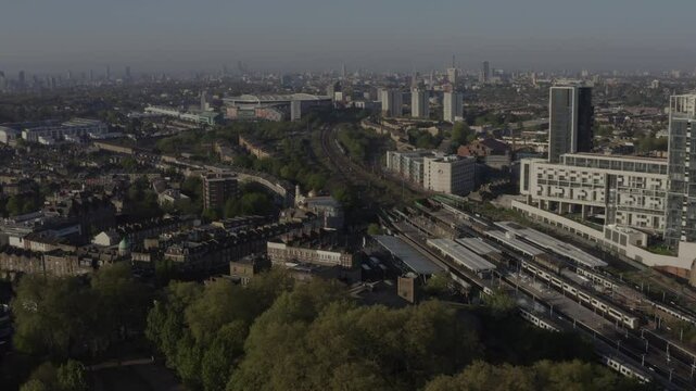 Wide aerial view of North London with mosque, Arsenal Emirates Stadium and Finsbury Park railway station in the foreground and sky scrapers in the background 