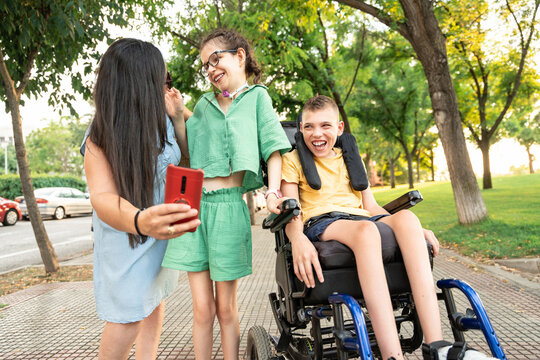 Mother capturing joyful moments with cheerful disabled kids