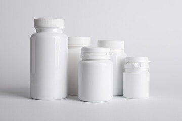 Many plastic medical bottles on white background