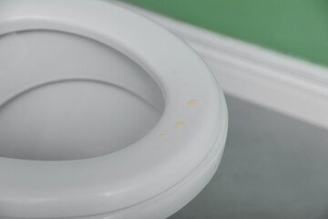 Urine drops on toilet seat in restroom, closeup