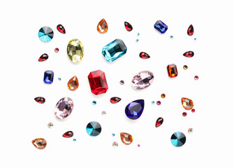 Different shiny gemstones on white background, flat lay