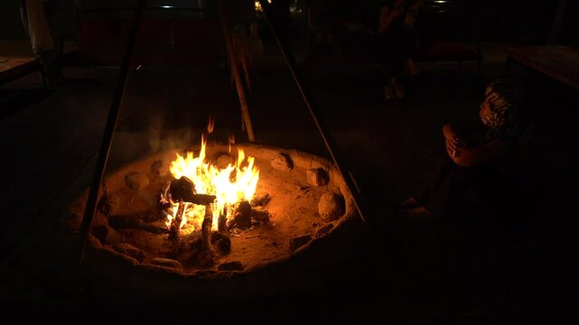 making a fire in nature in a  desert tour , brazier with embers and burning wood - night in camping and adventure on a tourist safari during a backpacking trip in Morocco Sahara desert 