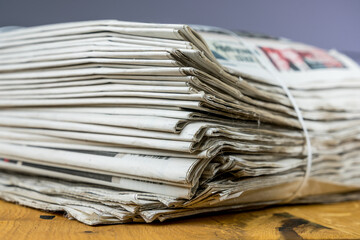 Tied pack of paper newspapers on wooden table