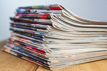 A pile of colorful magazines lying on wooden table