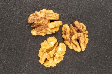 Shelled walnutson a slate stone, close-up, top view.