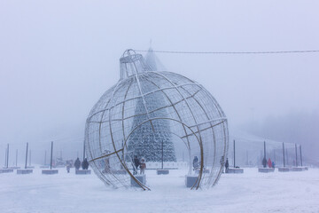Christmas tree in fog and snow and city Christmas decorations