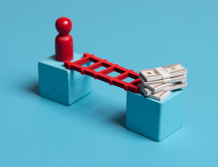Red wooden figures with stairs and banknotes on blue background.Concept of financial goals, cunning...