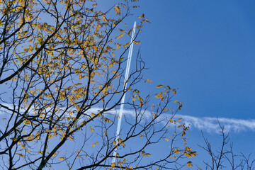 Vortex smoke trail from a French military jet aircraft bisecting the smoke trail from another jet aircraft highlighted against a beautiful blue sky

