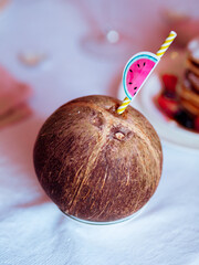 Coconut with a straw on a festive table close-up