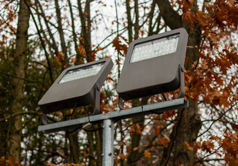 A tall street lamp with a metal pole and an elegant shade that spreads a soft and warm light.