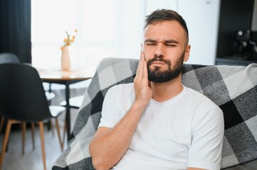 Dental health problems concept. Man suffering from strong toothache. Upset male patient with...