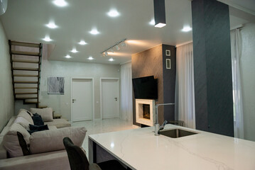 A room with a kitchen area and a fireplace.