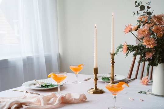 Elegant table setting with Mandarin drinks and lit candles