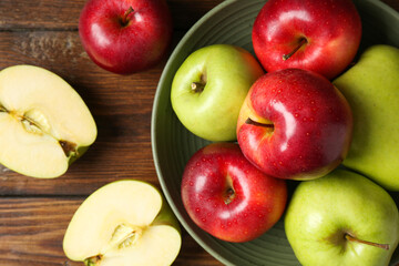 Fresh red and green apples on wooden table, flat lay