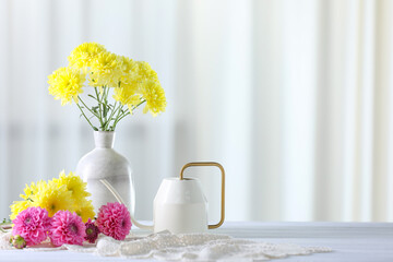Beautiful flowers in vase on white wooden table at home. Space for text