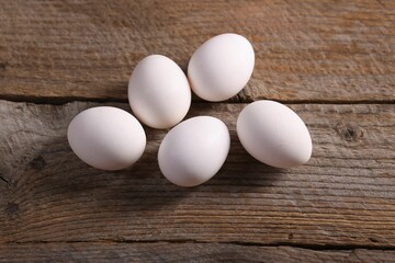 Many fresh eggs on wooden table, flat lay