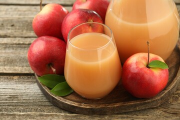 Tasty apple juice and fresh fruits on wooden table, closeup