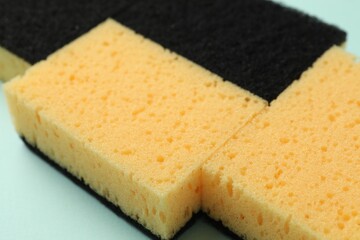 Color sponges on light blue background, closeup